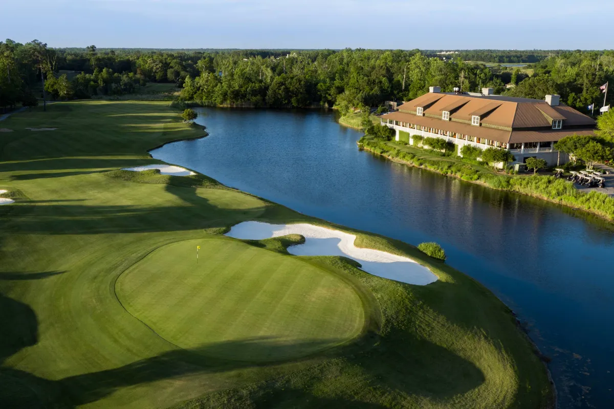 A panoramic view of a lush golf course with a tranquil lake, sand traps, a well-maintained clubhouse, and inviting walking trails. The atmosphere is peaceful, ideal for both active recreation and quiet enjoyment of the outdoors.